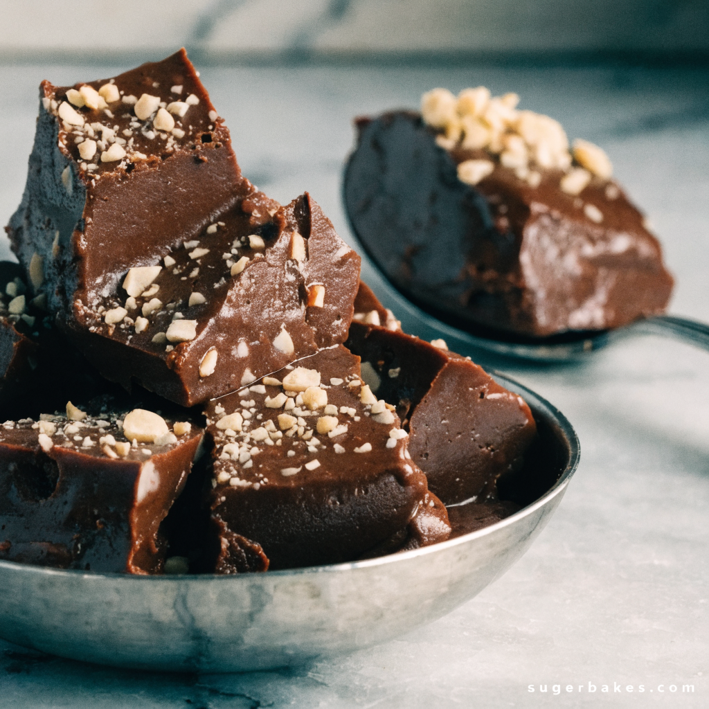 A close-up of a square piece of chocolate fudge with a heart-shaped indentation on top. easy fudge recipe