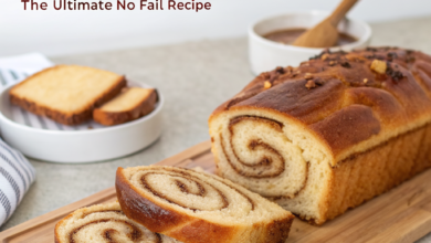 A slice of fluffy homemade cinnamon swirl bread shows a dark spice spiral and golden crust on a wooden board.